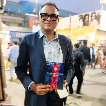 Kalyan Mukhopadhyay, in a navy jacket, holding a book.