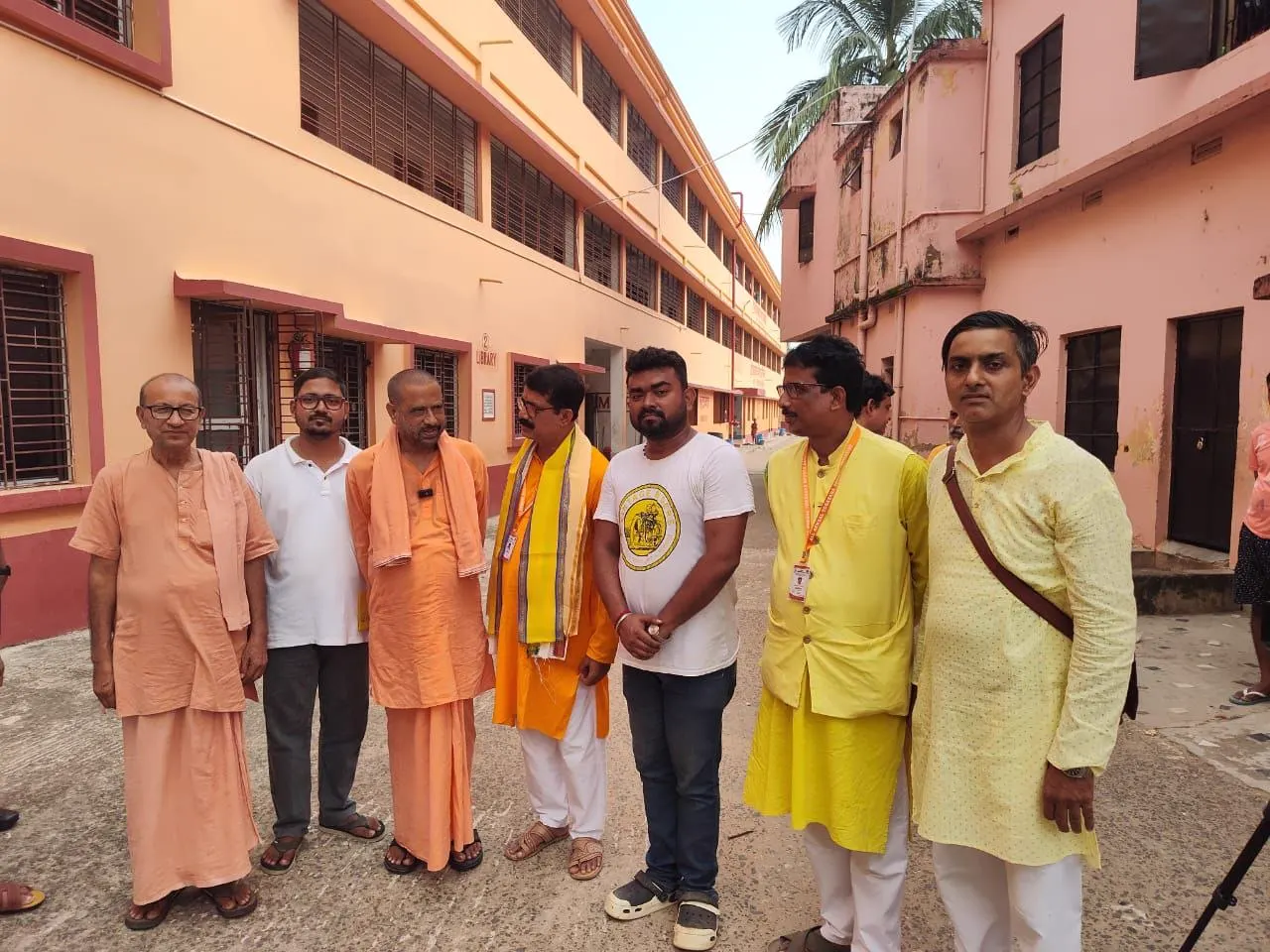 Shyamal Ta, State President of the All Bengal Yogasana Sports Association, stands with officials and organisers in the courtyard at Bharat Sevashram Sangha, Muluk.