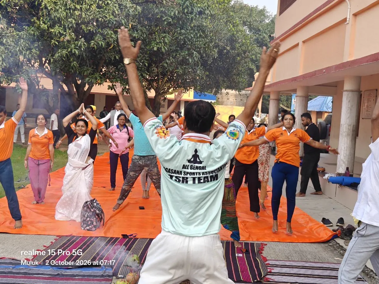 The group raises both arms, led by the All Bengal Yogasana Sports Association team.